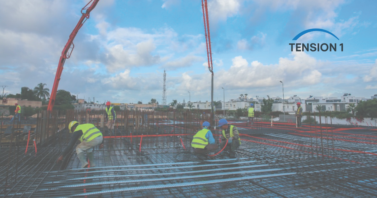 A construction crew pouring and leveling concrete over a post tension slab grid to illustrate project timeline efficiency and material savings.